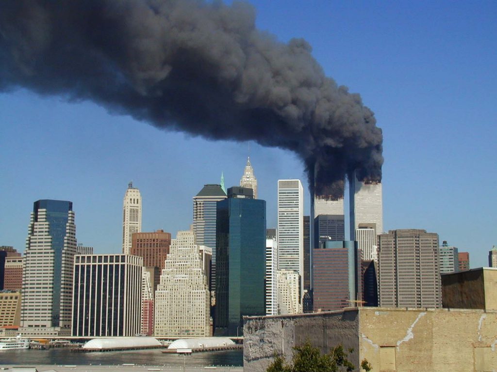 Plumes of smoke billow from the World Trade Center towers in Lower Manhattan, New York City, after a Boeing 767 hits each tower during the September 11 attacks © 2001 Michael Foran